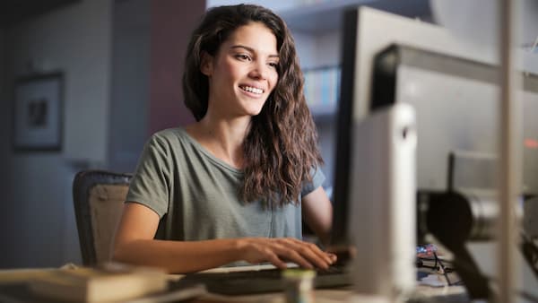 Chica sonriente frente a un ordenador